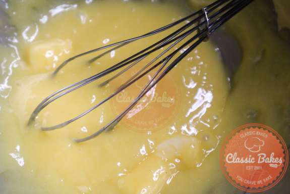 Butter being whisked into lemon curd filling. 
