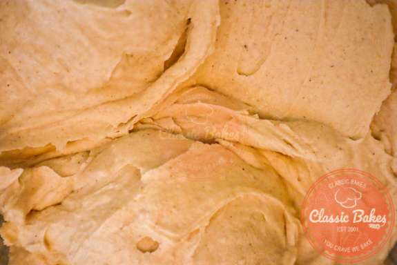 Cinnamon buttercream frosting in a stand mixer bowl.