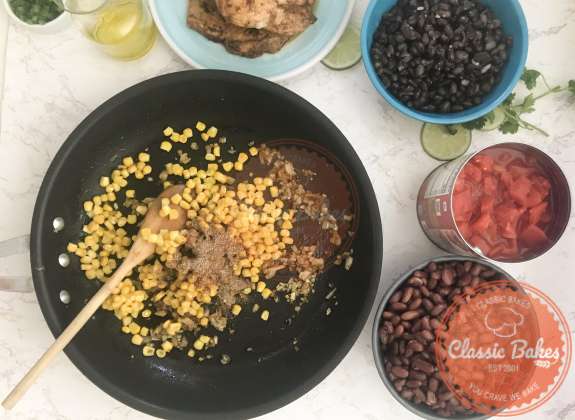 Corn and taco seasoning being added to a pan 