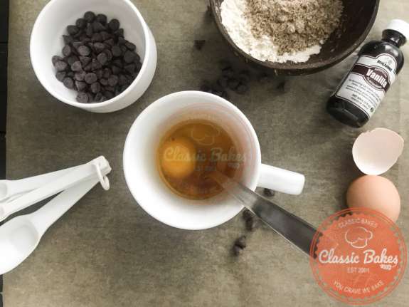 Egg yolk and vanilla being mixed into a mug 