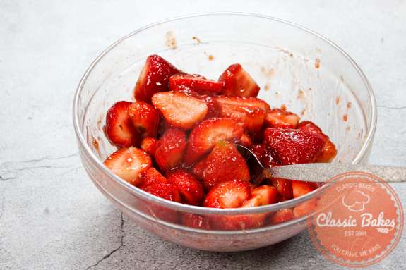 Fresh strawberries being mixed with strawberry preserves 