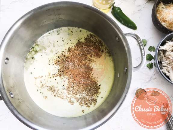 Green Chilies, cream and spices simmer in a pot 