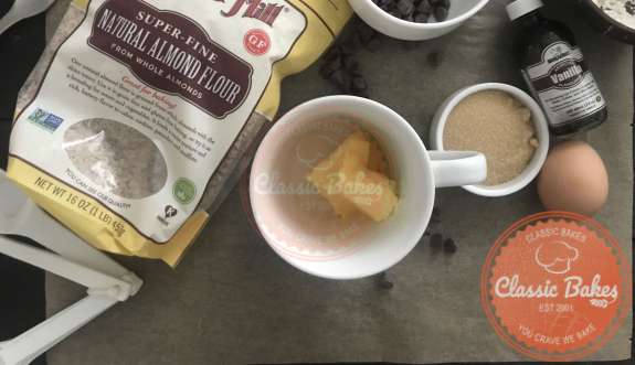 Overview of a mug with butter and cookie ingredients 