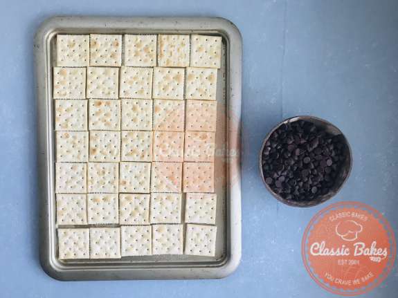 Overview of saltine crackers arranged on a baking tray 