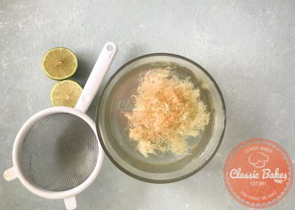 Overview of Sea Moss soaking in a bowl of water with lime juice next to a strainer