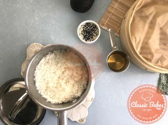 Overview of sushi rice resting in a pot on a countertop 