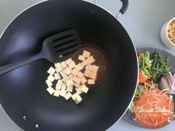 Overview of tofu being cooked in a wok 