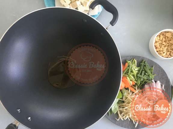 Overview of a wok with peanut oil heating up inside it 