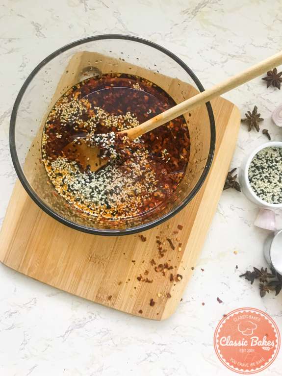 Sesame seeds and oil being stirred into chili oil