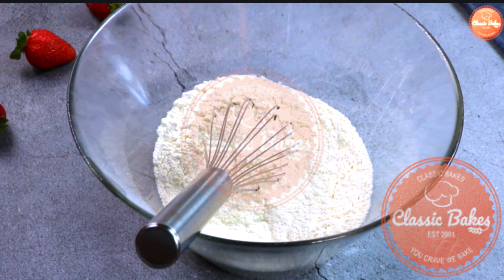 Sideview of dry ingredients being mixed together using a whisk 