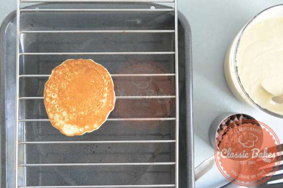 Overview of a pancake on a cooling rack with a baking sheet underneath it 