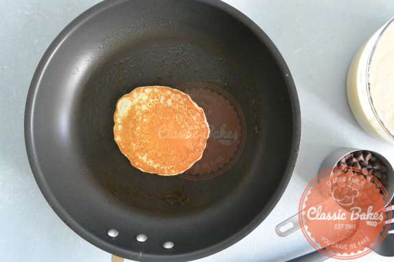 Pancake being flipped and cooking in a pan 