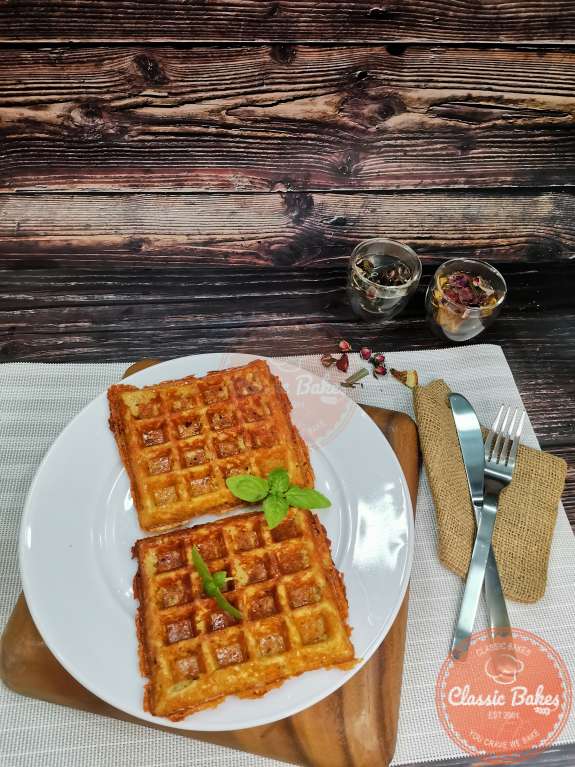 Side view of two cauliflower waffles on a plate