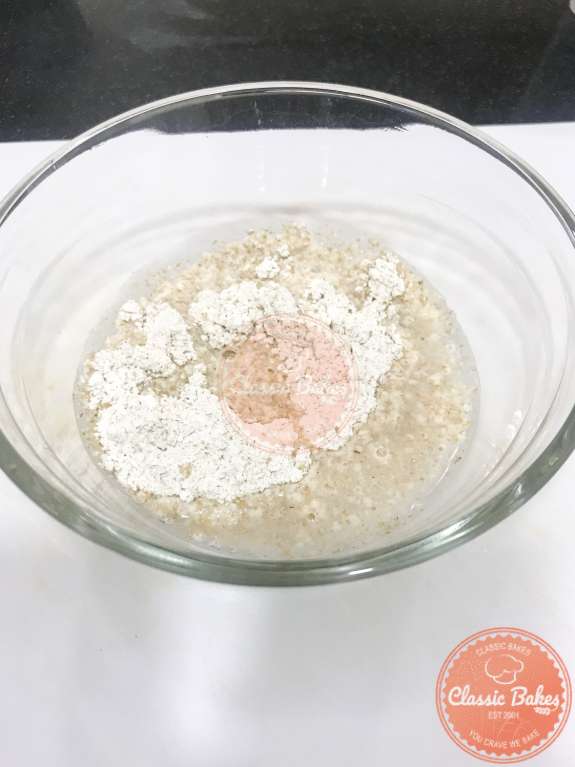 Liquid being added to a bowl of dumpling dough 