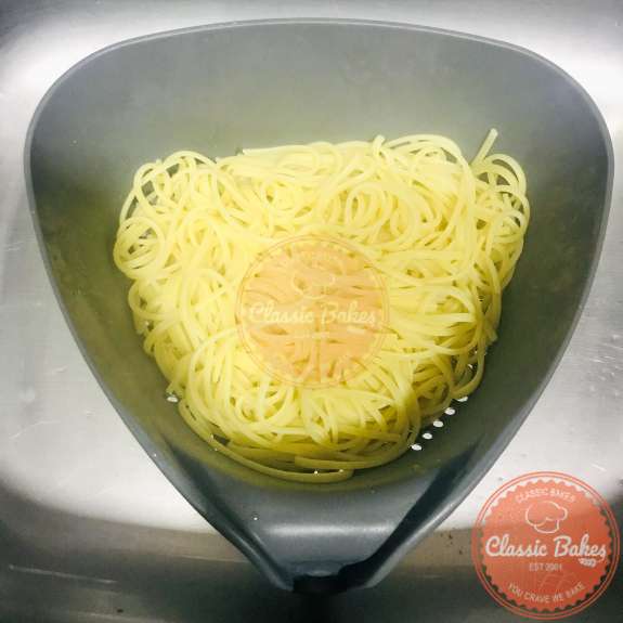 Overhead shot of linguine being drained in a colander