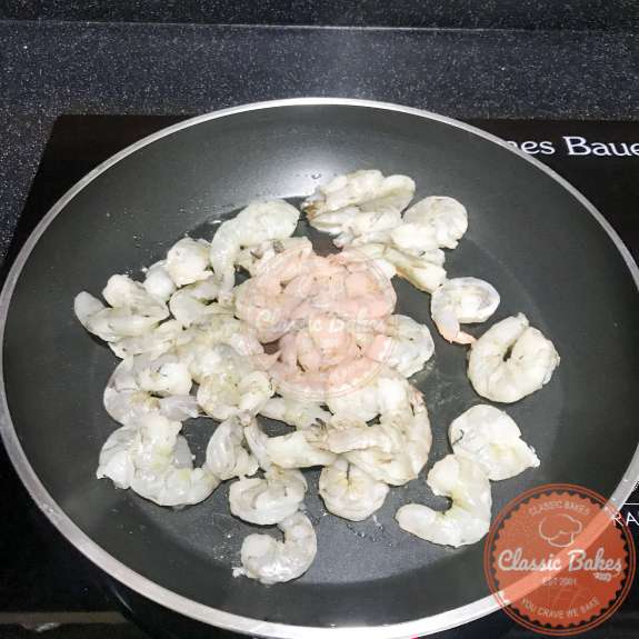 Overview of shrimp being sauteed in a pan 