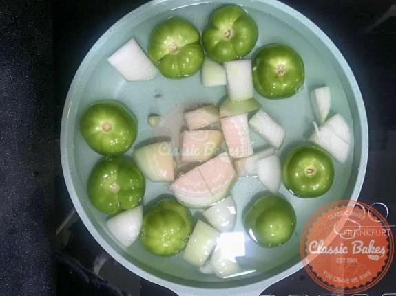 Overview of tomatillos, onions and garlic cooking in water 