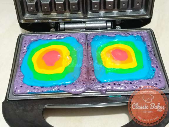 Pipe the rainbow batter into the waffle maker