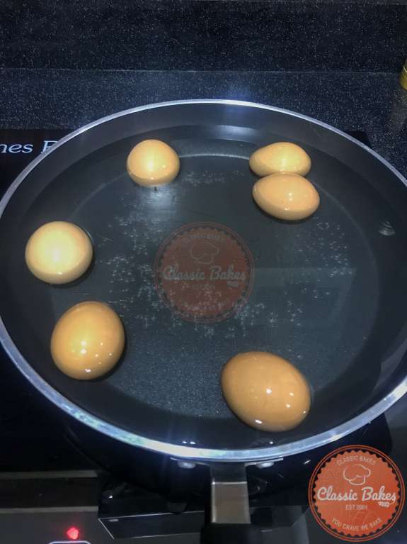 A sauce pan filled with water and eggs 