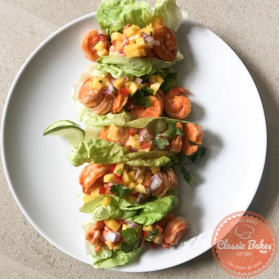 Overview of shrimp lettuce wraps lined up on a plate
