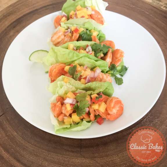 Side view of shrimp lettuce wraps on a wooden tabletop 