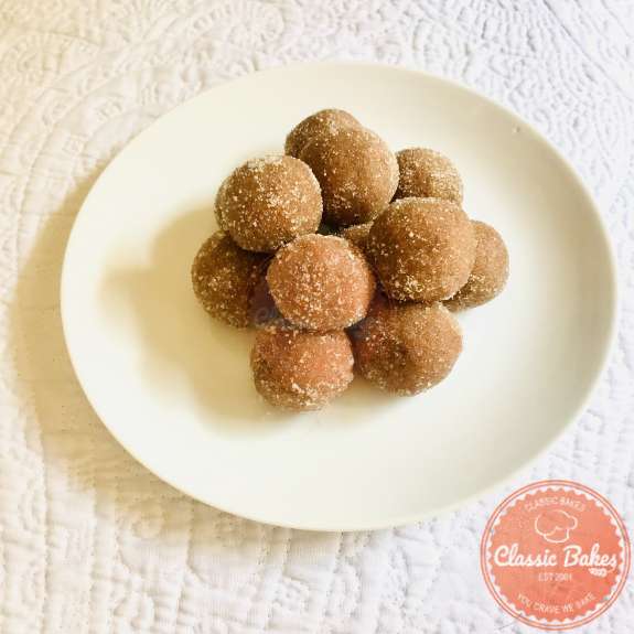 Side view of a plate of tamarind balls dusted with sugar