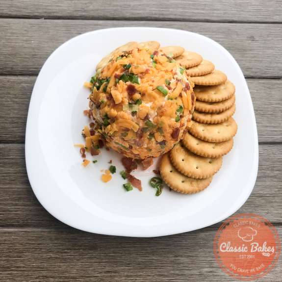 Overview of a keto cheese ball with cheddar, bacon and green onions rolled on the outside