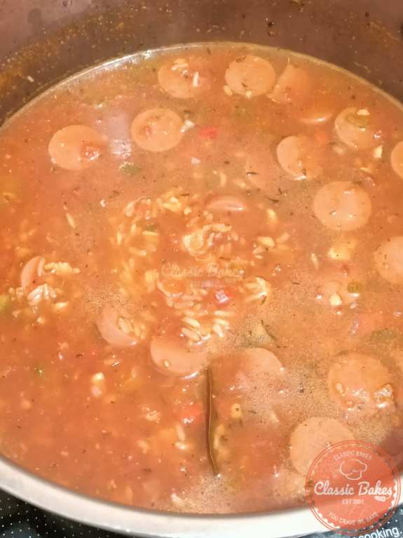Adding chicken broth, tomatoes, rice and seasonings