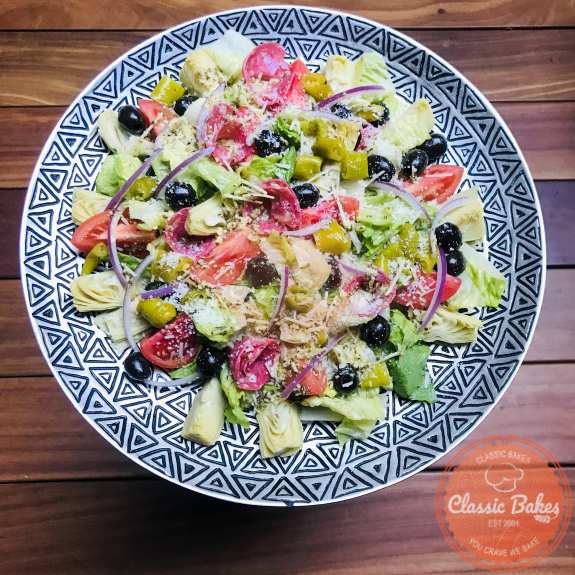 A platter of antipasto salad coated with dressing