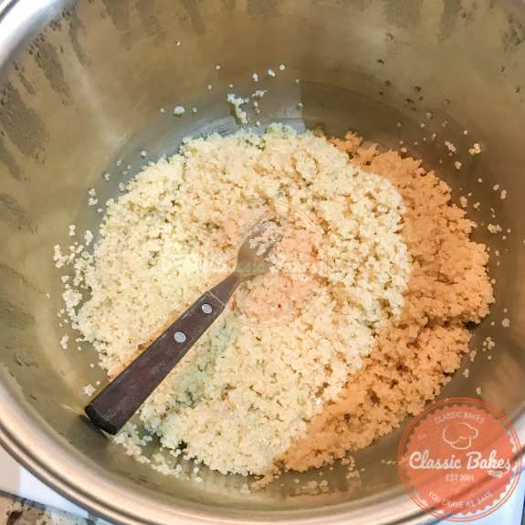Cooked quinoa being fluffed with a fork 