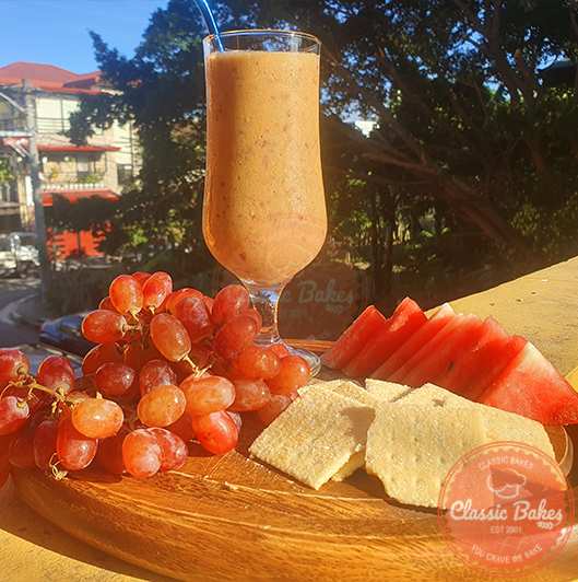 Grape Smoothie with fruits and crackers on the side.