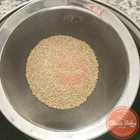 Quinoa being rinsed in a strainer 