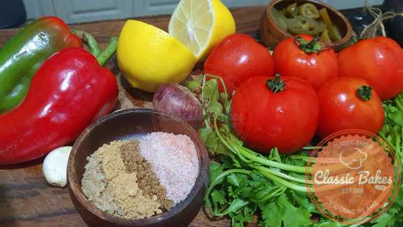 Garlic, cumin, coriander, sugar, himalayan salt, lime juice, cilantro, red onion, jalapenos, bell peppers, cumin, and all of these ingredients should be put in a food processor.