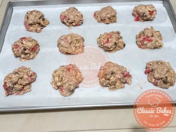 Scooping strawberry oatmeal cookies into the baking pan