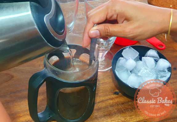 Put the ground coffee at the base of a French press, then use a spoon to blend everything together as you pour the water over the coffee.