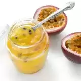 Aerial shot of Passion Fruit Sauce in a jar with passion fruits on the side