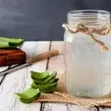 Side shot of Aloe Vera Juice in a bottle with aloe vera on the side