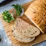 Hard Dough Bread with Roasted Garlic on top of wooden board