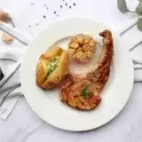 Baked BBQ Pork Chops with Potatoes with knife and fork on the side