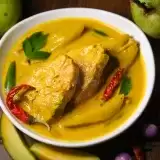 Close Up King Fish Curry with fresh fruits and vegetables on the side