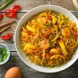 Aerial View of Stir Fried Singapore Noodles with ingredients and chopsticks on the side