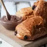 Front shot of 3 pieces of Chocolate Croissant with chocolate on side
