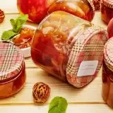 Chunky peach chutney in glass jar in wooden table