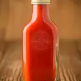 Bottle of Trinidad Hot Sauce in wooden background