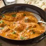 Front shot of Keto Butter chicken in a skillet with a spoon