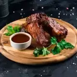 Front shot of Smoked Pork Spare Ribs in wooden plate