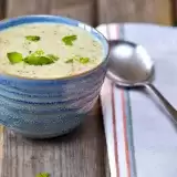 Front shot of Instant Pot Broccoli Cheddar Soup in a bowl with spoon and cloth on the side