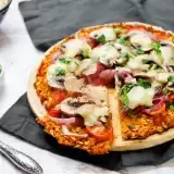 Front shot of sliced Sweet Potato Pizza Crust in a plate with a knife on the side