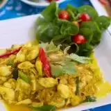 Front shot of Tobago Coconut Curry Crab in a plate with garnish and chilli on the top
