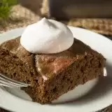 Close up shot of Vegan Gingerbread Cake in a plate with cream on top